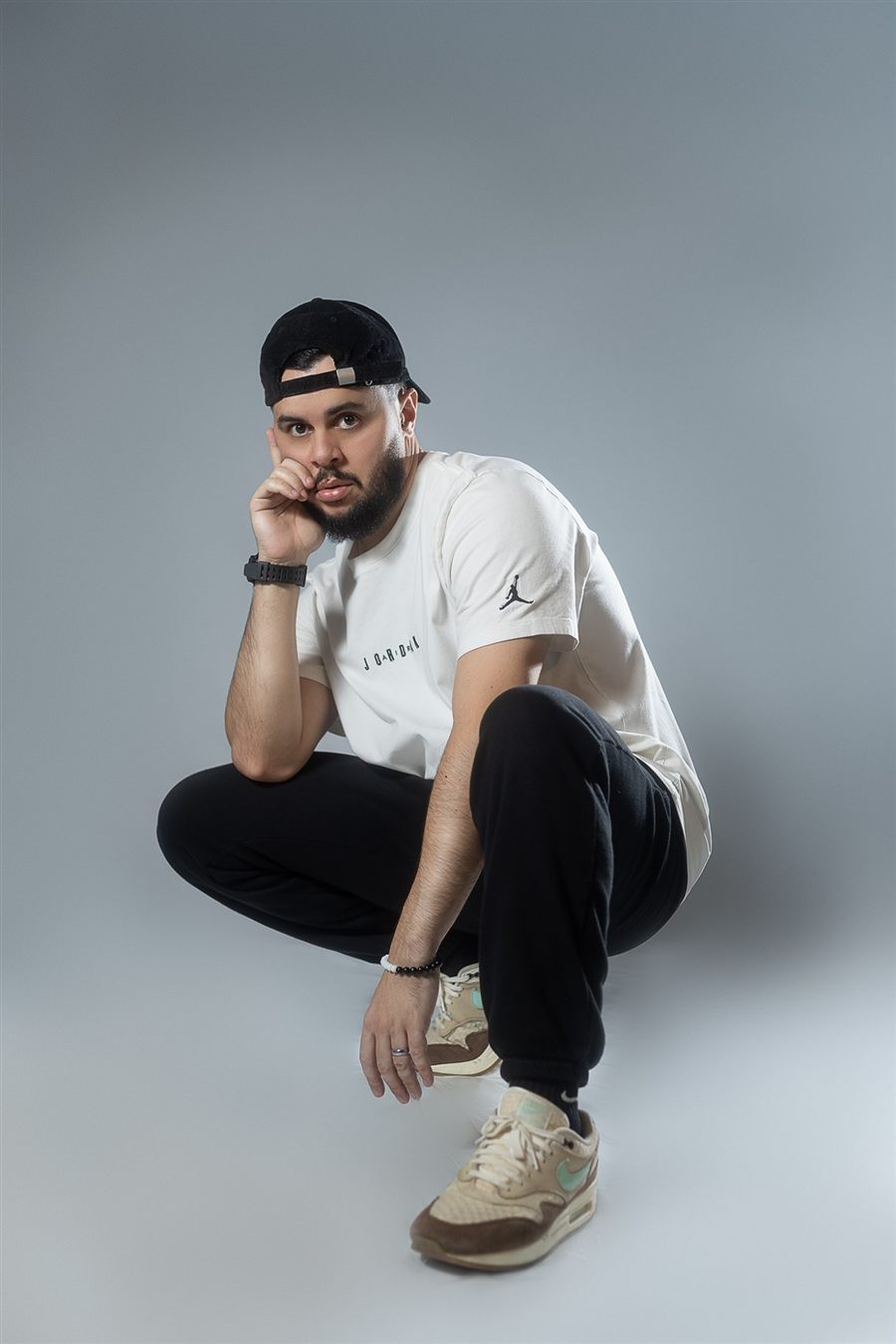 Brasileirada's founder and lead instructor crouching in a white tee and backwards cap